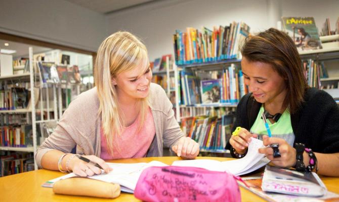 une adolescente en bibliothèque avec sa mentor