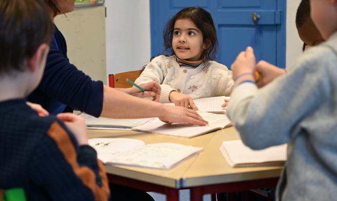 des enfants autour d'une table avec des supports de lecture